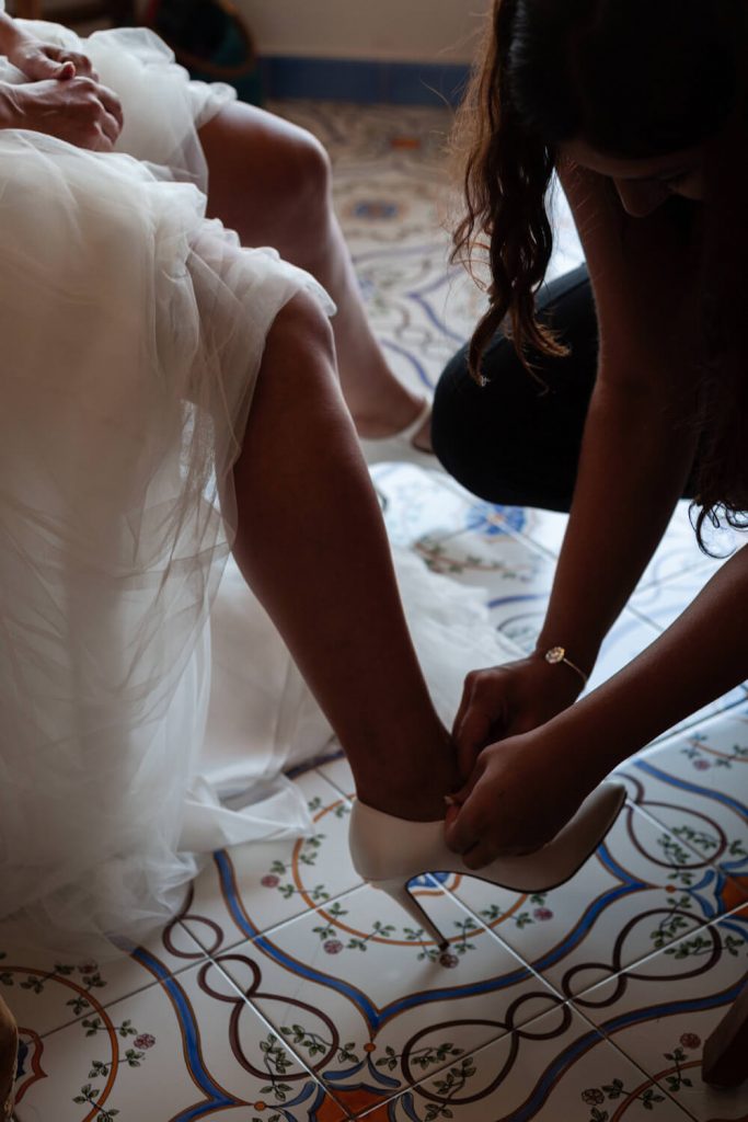 close up of bride putting shoes on