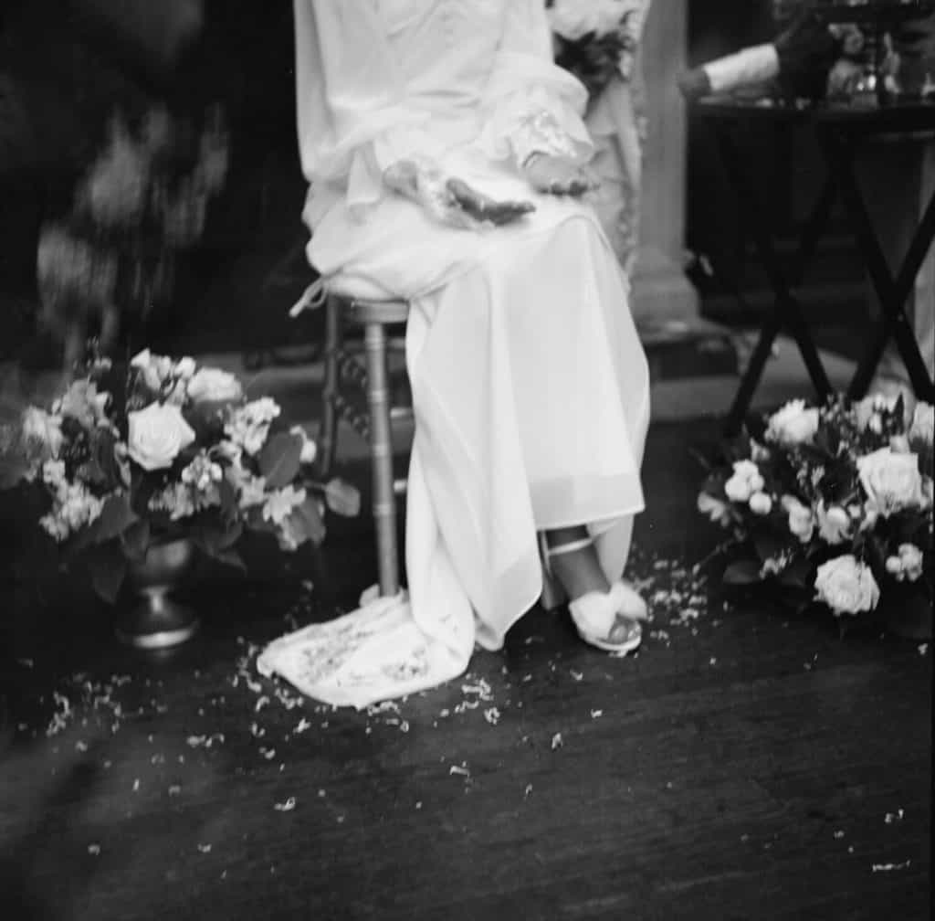 detail of brides hands and shoes on black and white film