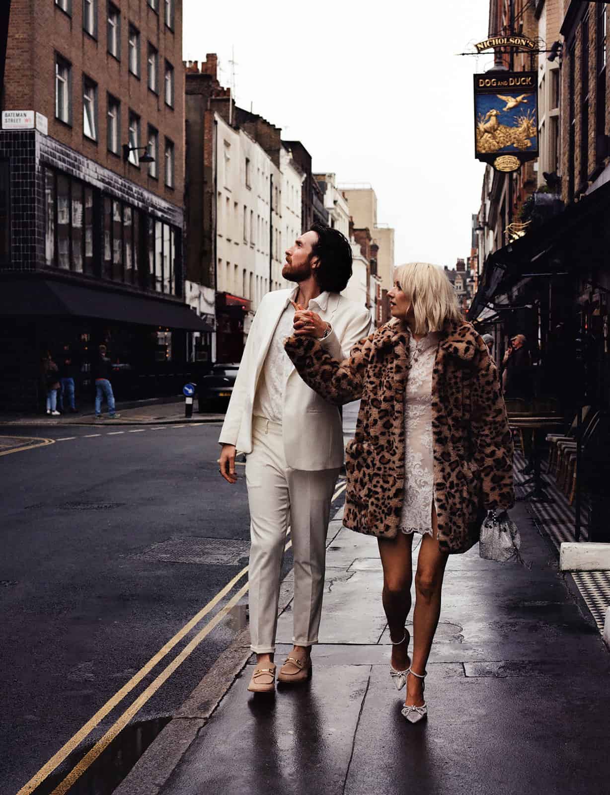 bride and groom walk through soho london 35mm