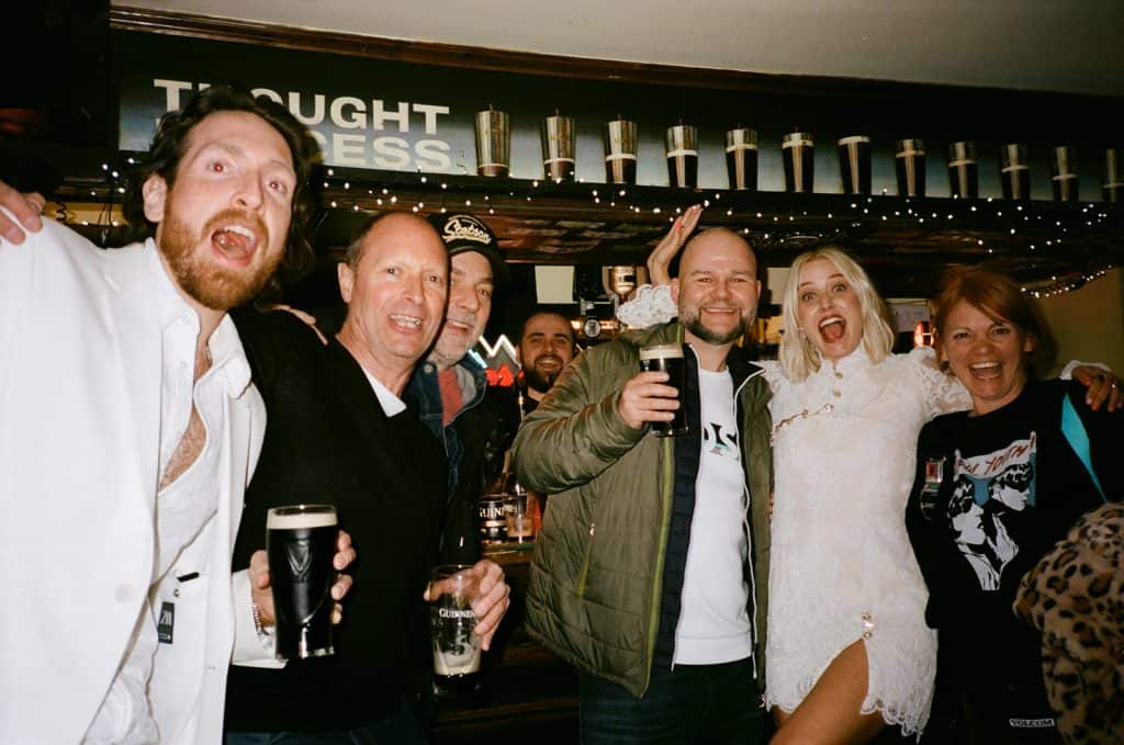 group photo of pub guests in the toucan for a wedding on film