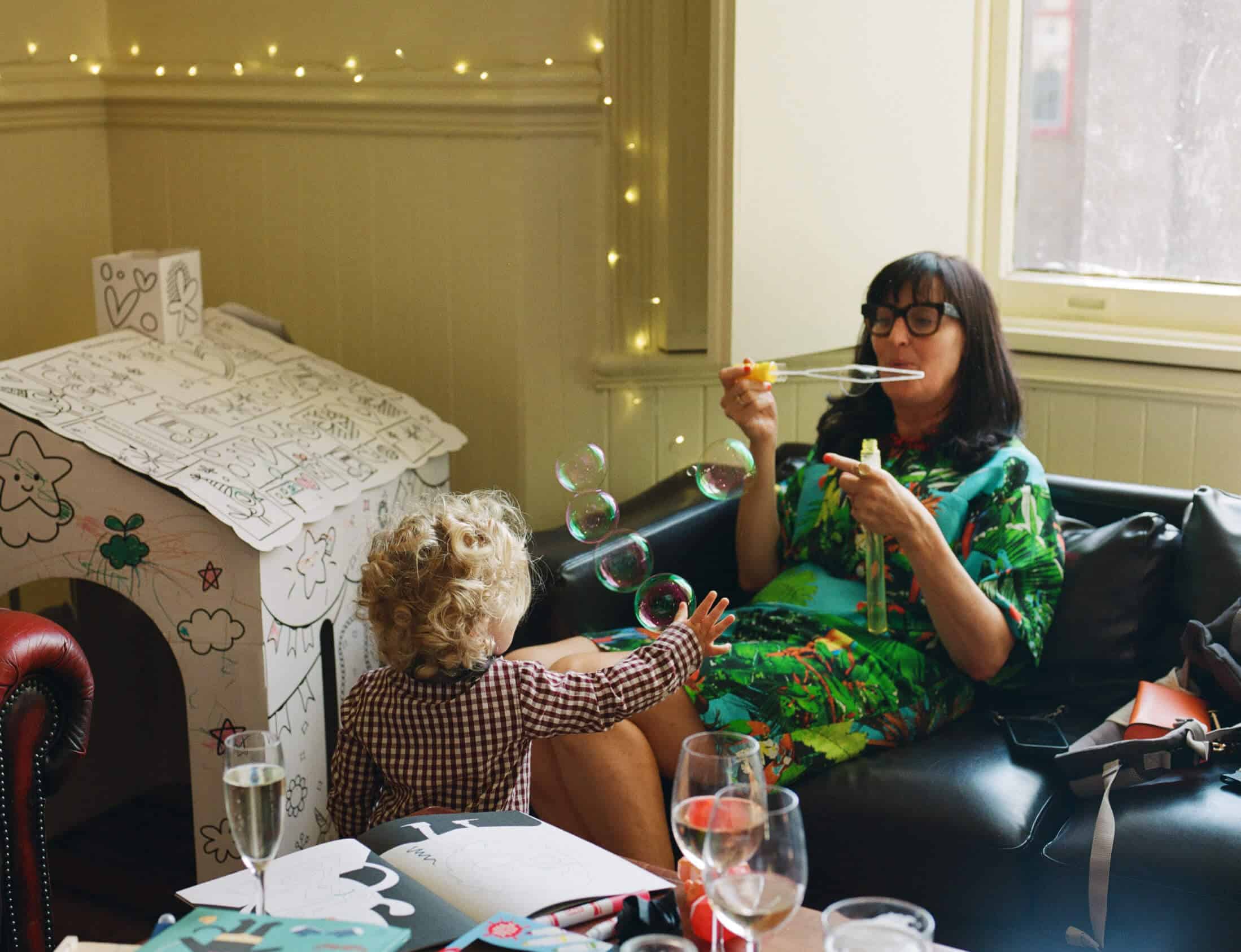 wedding guest blows bubbles for little boy on 35mm