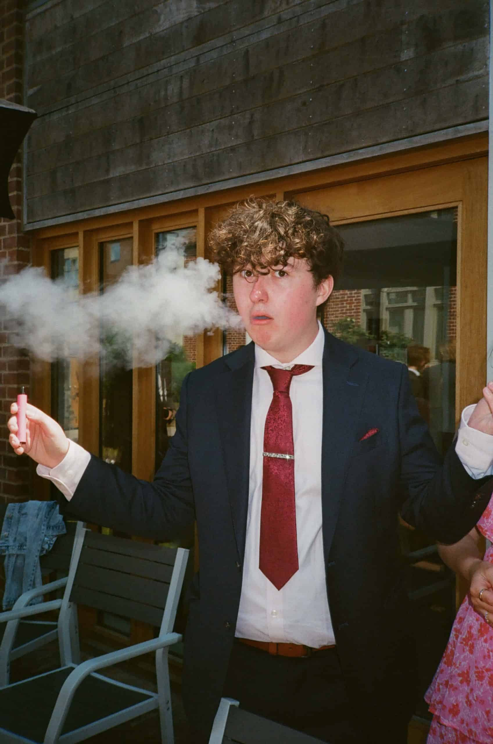 best man blowing out a plume of smoke
