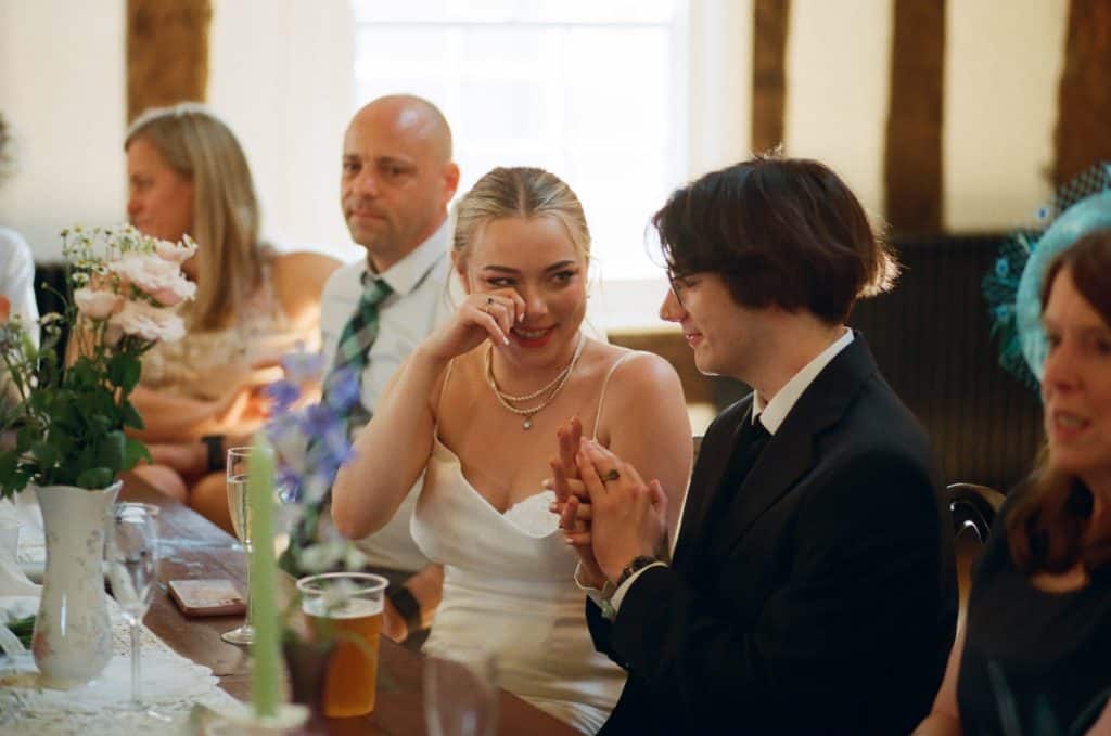 bride and groom hold hands during speech
