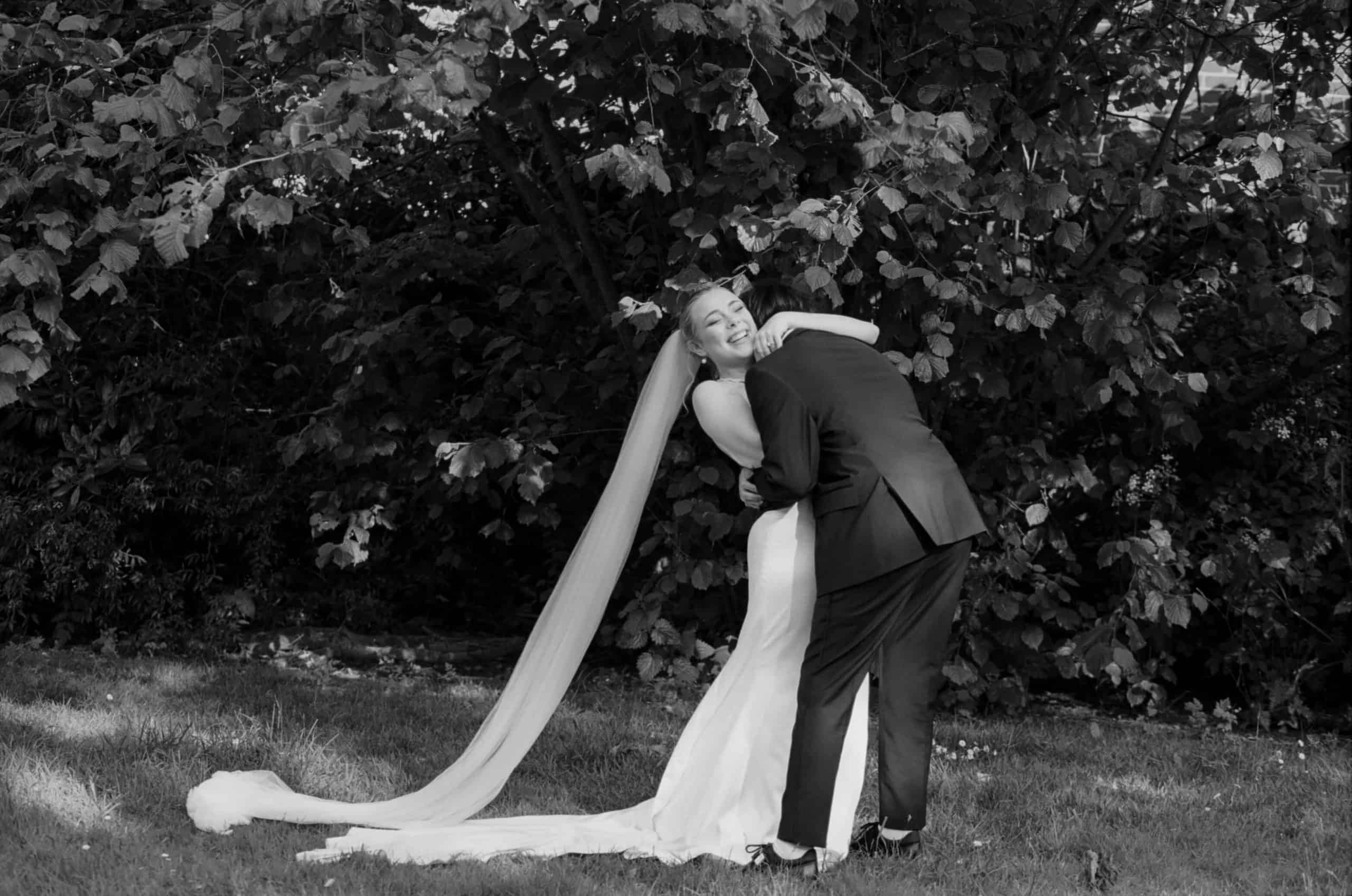 bride and groom hugging on black and white film
