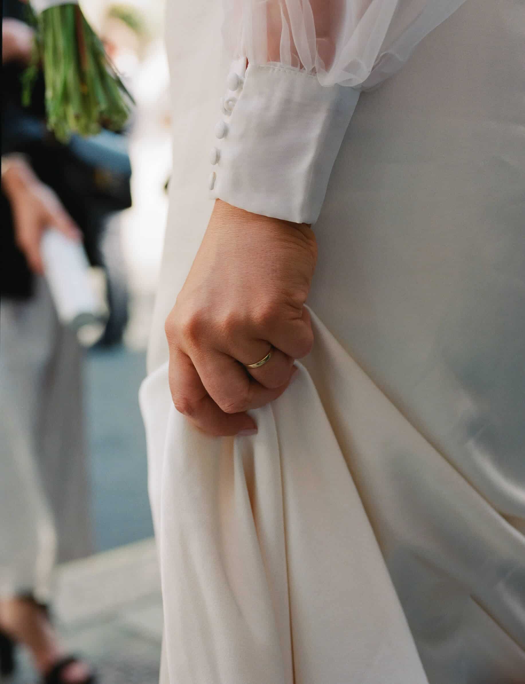 detail of wedding ring and dress on 35mm