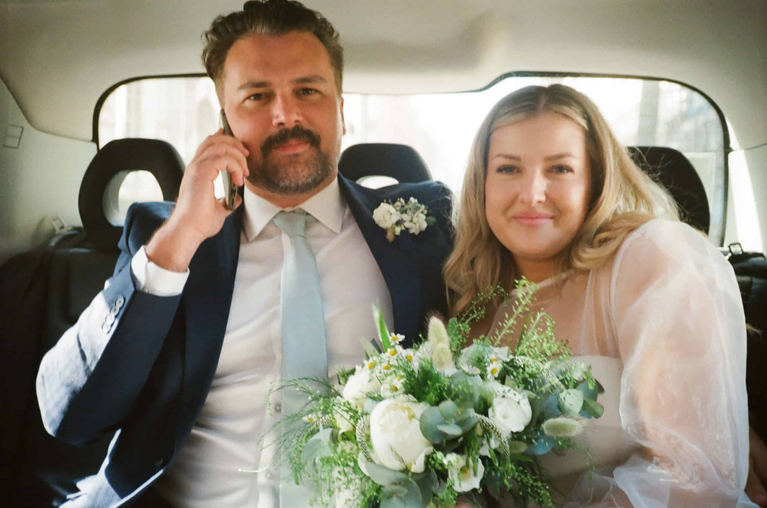 bride and groom in black cab on 35mm